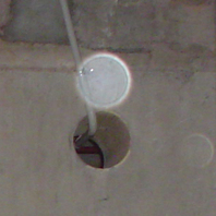close up of dust orb and hole in concrete, Basement, Wellington Museum of City and Sea, non-paranormal dust orb, Strange Occurrences paranormal investigation, Wellington NZ 